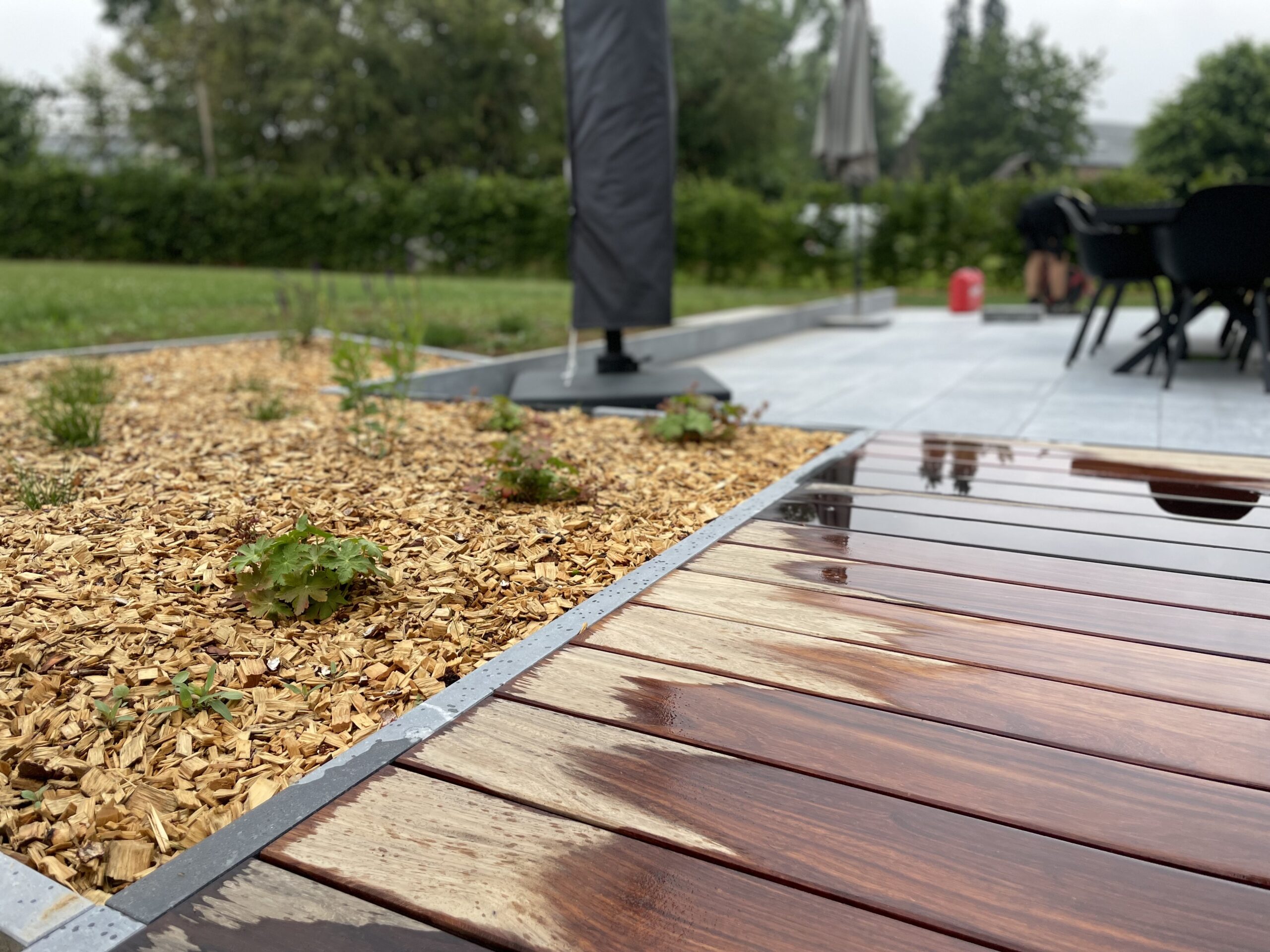 Terrasse en pierre bleue belge, bois exotique, can niveaux discret et plantations. Portail et parking sur l'avant