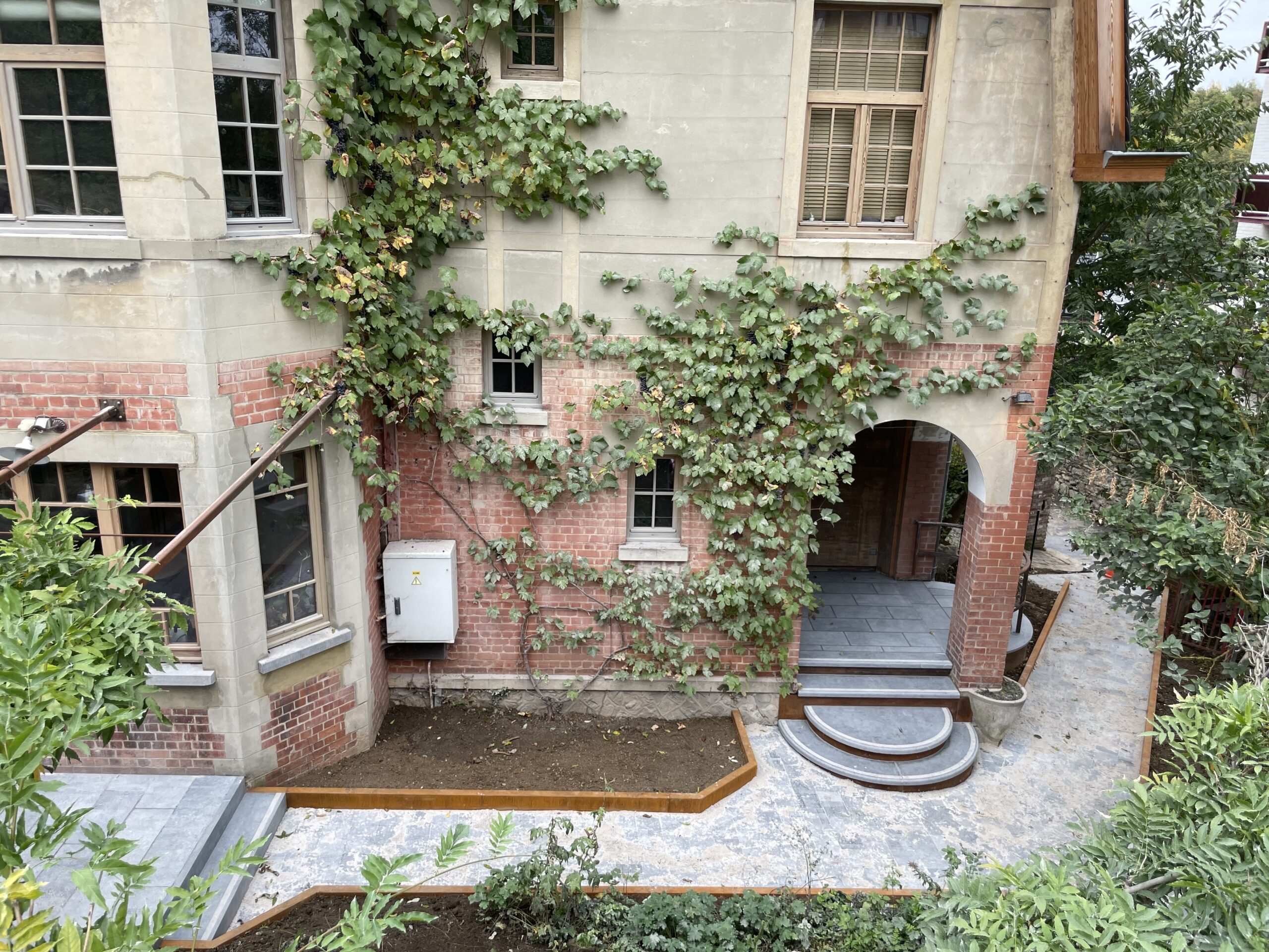 Aménagement complet de ce jardin de ville en associant la pierre bleue et l'acier corten